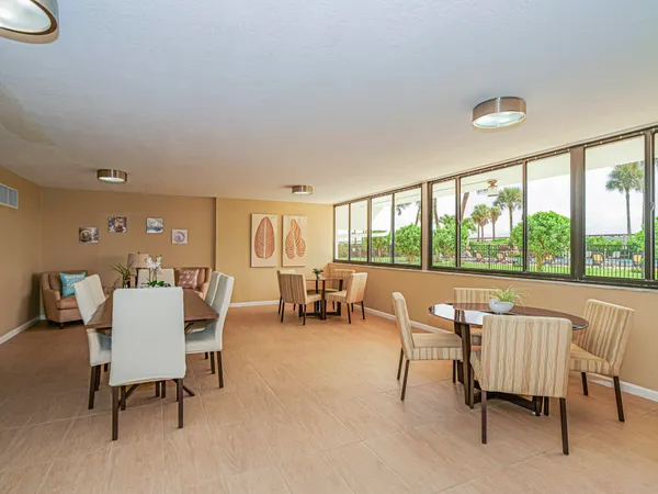 a dining room with furniture and a floor to ceiling window