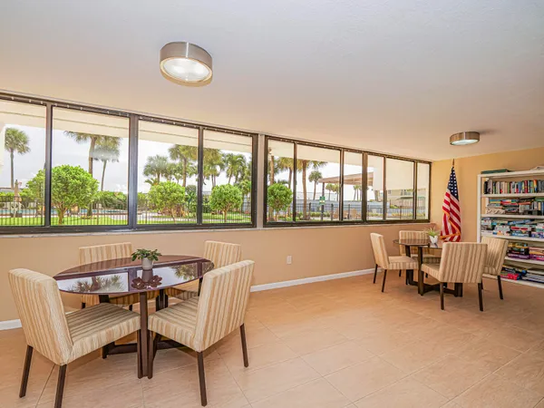 a dining room with furniture and a large window