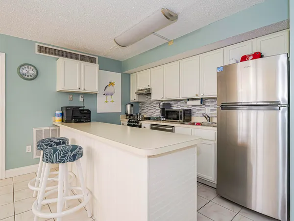 a kitchen with a refrigerator a stove top oven a sink and cabinets