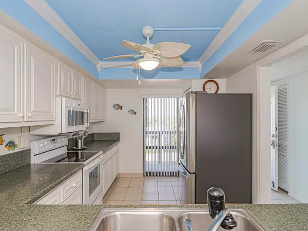 a kitchen with granite countertop a sink stainless steel appliances and cabinets
