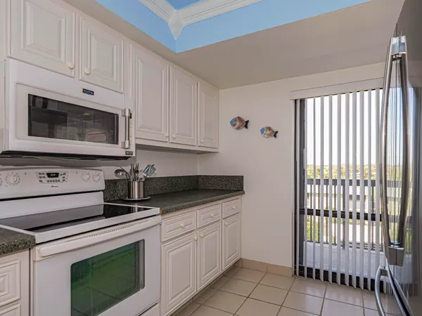 a kitchen with granite countertop white cabinets and white appliances