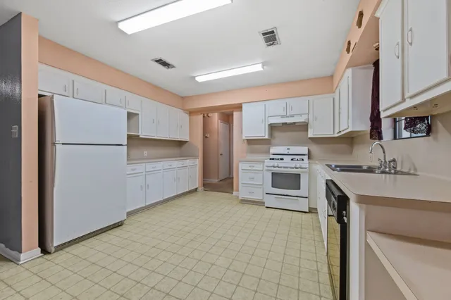 a kitchen with stainless steel appliances a refrigerator sink and cabinets