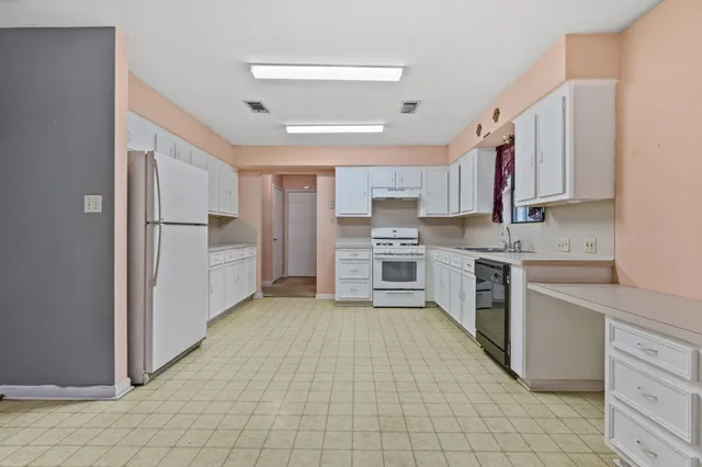 a kitchen with stainless steel appliances a refrigerator sink and cabinets
