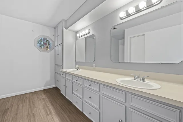 a bathroom with a granite countertop sink a mirror and a shower