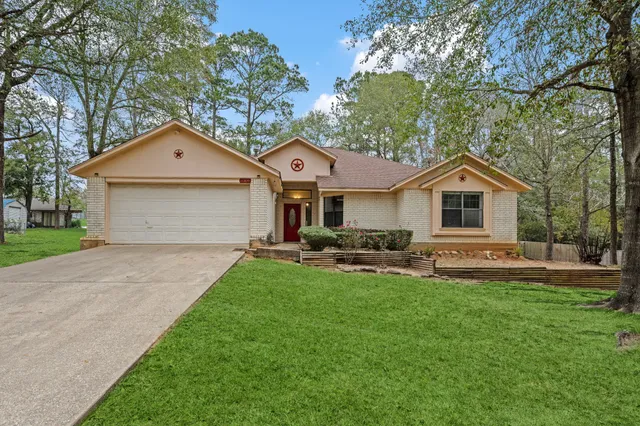 a front view of a house with yard and trees