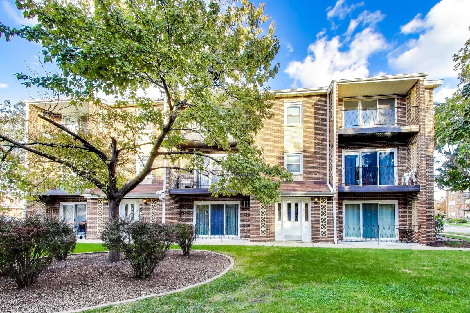 6416 West 64th Place, Unit 3A Chicago, IL 60638 - Photo 1 of 1 a view of a brick house with a yard plants and a large tree