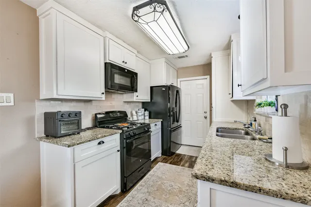 a kitchen with stainless steel appliances granite countertop a stove a sink and a microwave