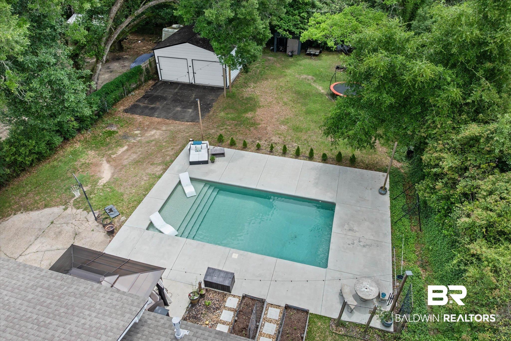 4213 Shan Drive East Mobile, AL 36693 - Photo 30 of 35 Expansive backyard featuring a rectangular in-ground swimming pool with concrete decking, a detached two-car garage, and mature perimeter trees