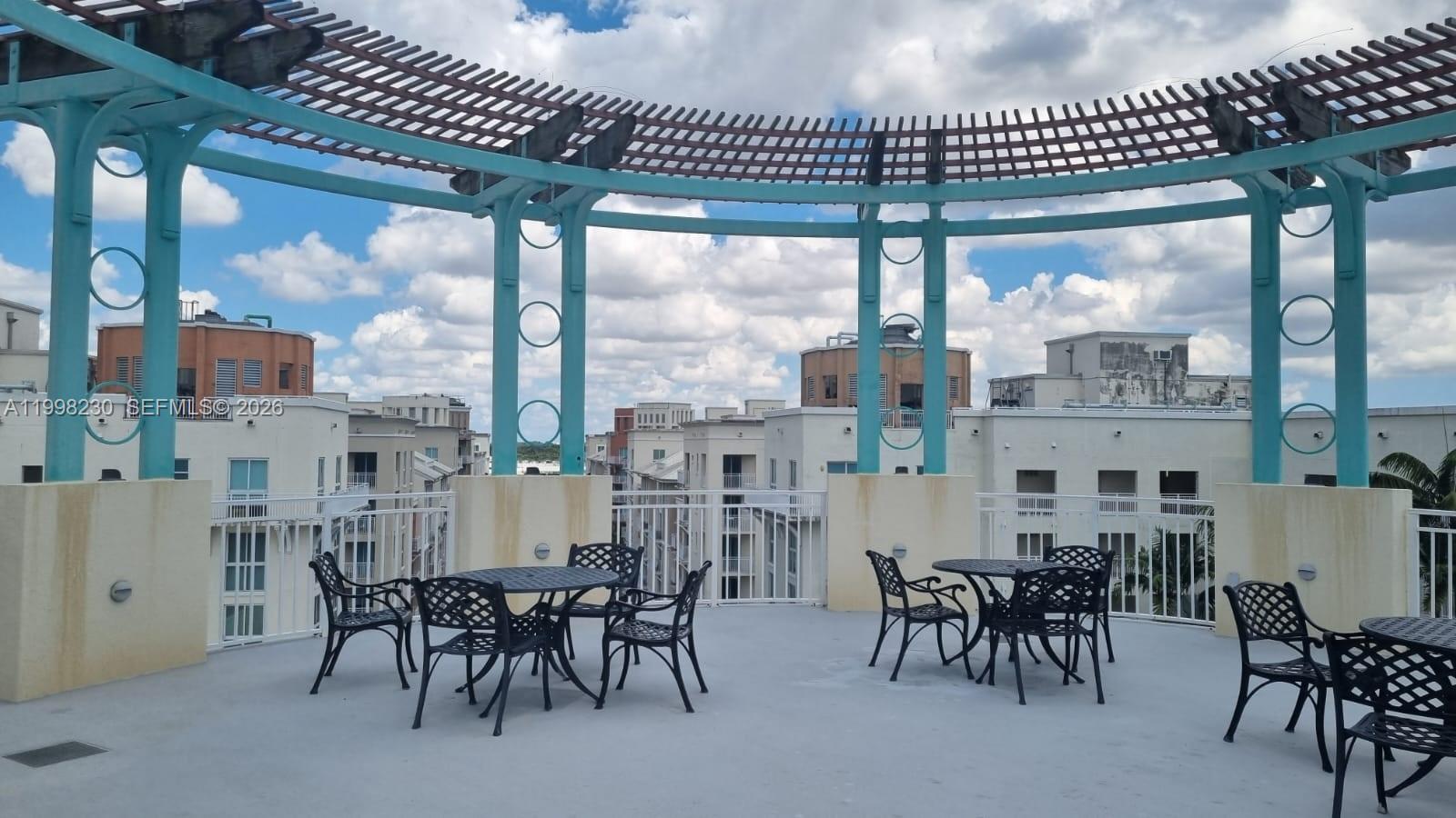 7270 Southwest 88th Street, Unit B306 Miami, FL 33156 - Photo 22 of 25 a dining area with furniture a chandelier and a large window