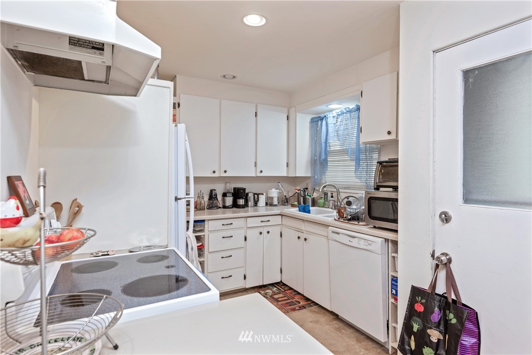 929 North 35th Street Seattle, WA 98103 - Photo 12 of 17 a kitchen with a sink a stove and white cabinets