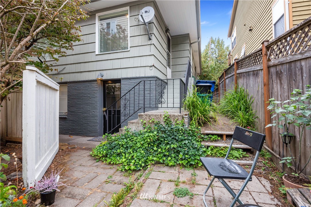 929 North 35th Street Seattle, WA 98103 - Photo 16 of 17 a backyard of a house with chairs and a lots of flower plants