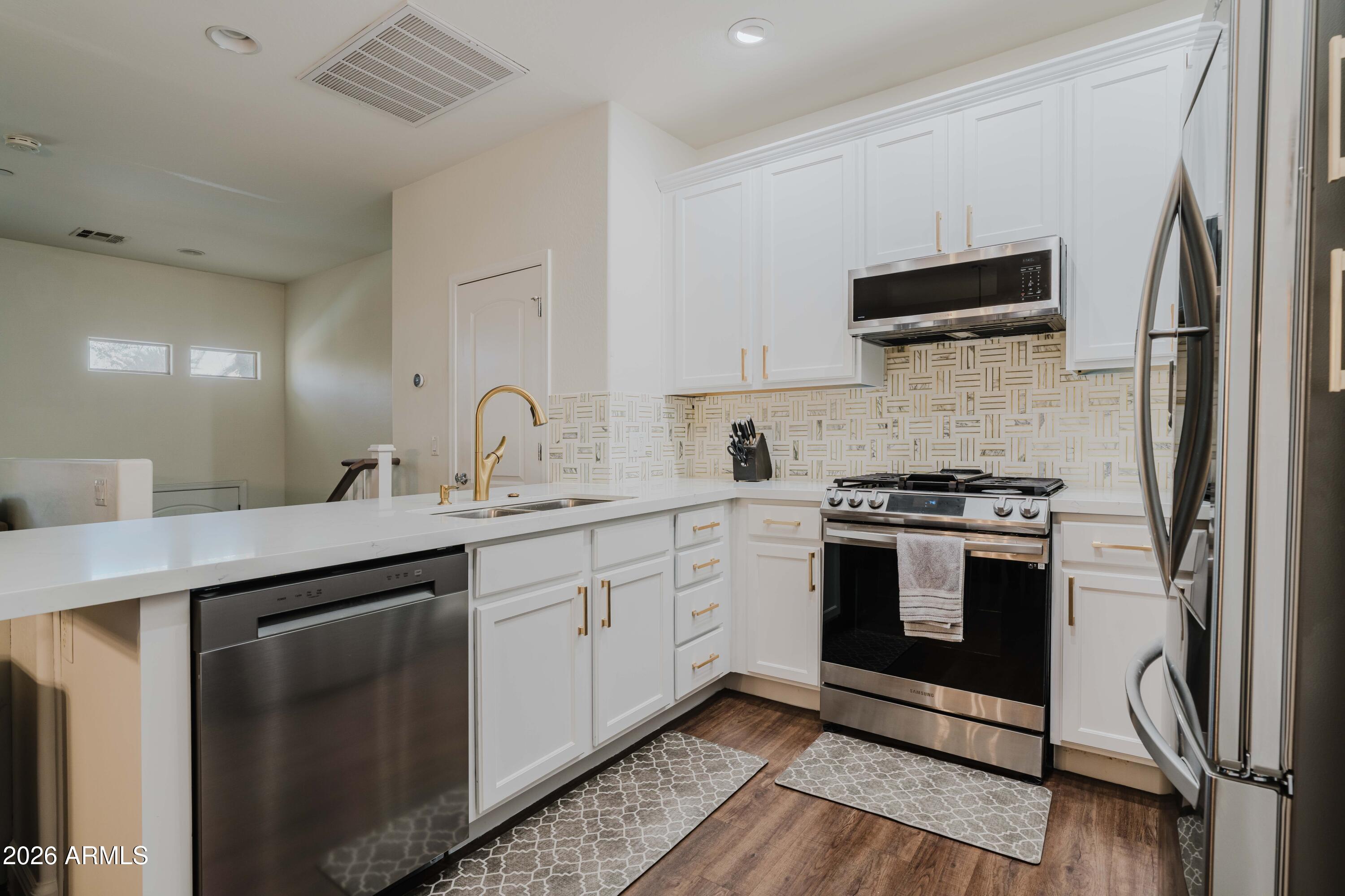 5550 North 16th Street, Unit 131 Phoenix, AZ 85016 - Photo 5 of 25 a kitchen with stainless steel appliances white cabinets a sink and a stove
