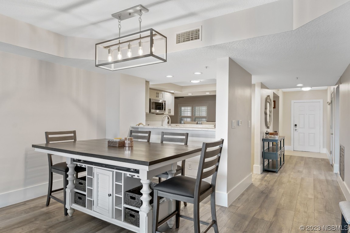 4650 Links Village Drive, Unit A301 Ponce Inlet, FL 32127 - Photo 11 of 54 a view of a dining room with furniture and wooden floor