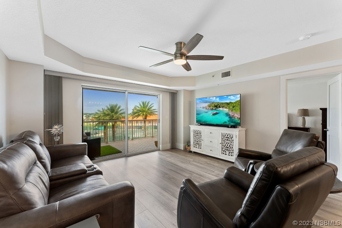 4650 Links Village Drive, Unit A301 Ponce Inlet, FL 32127 - Photo 13 of 54 a living room with furniture a flat screen tv and a large window