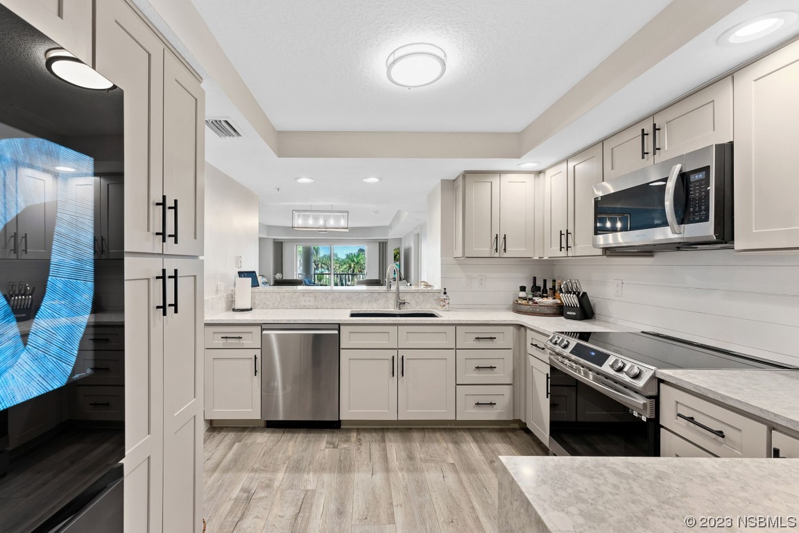 4650 Links Village Drive, Unit A301 Ponce Inlet, FL 32127 - Photo 6 of 54 a kitchen with stainless steel appliances a stove sink and cabinets