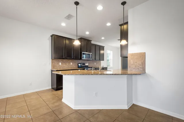 a kitchen with granite countertop stainless steel appliances and wooden cabinets