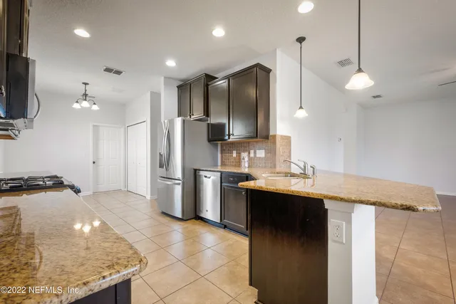 a kitchen with stainless steel appliances granite countertop a refrigerator and a sink