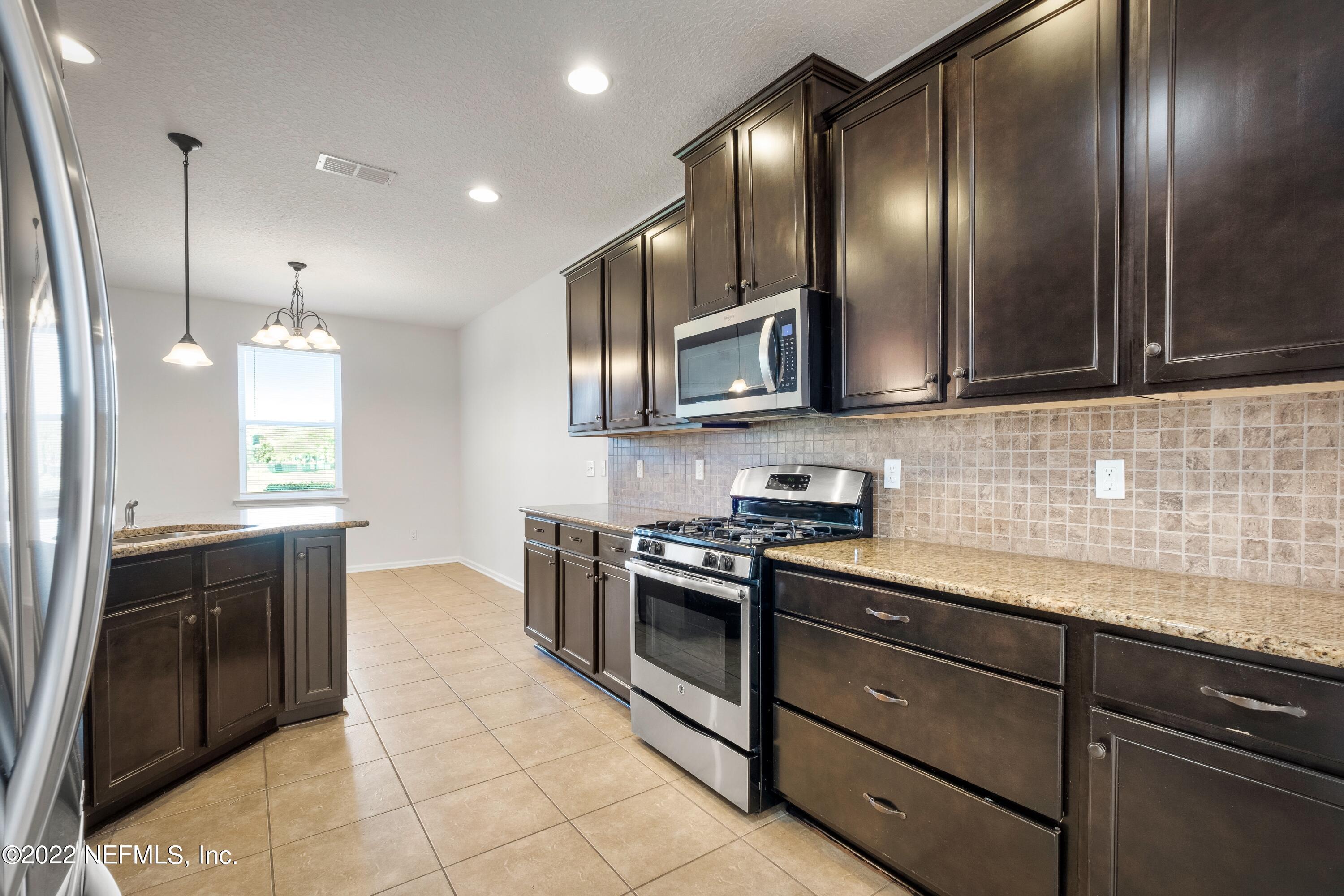 157 Heron Landing Road St. Johns, FL 32259 - Photo 17 of 40 a kitchen with granite countertop stainless steel appliances and sink