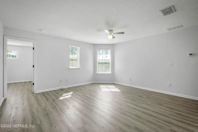 wooden floor in an empty room with a window