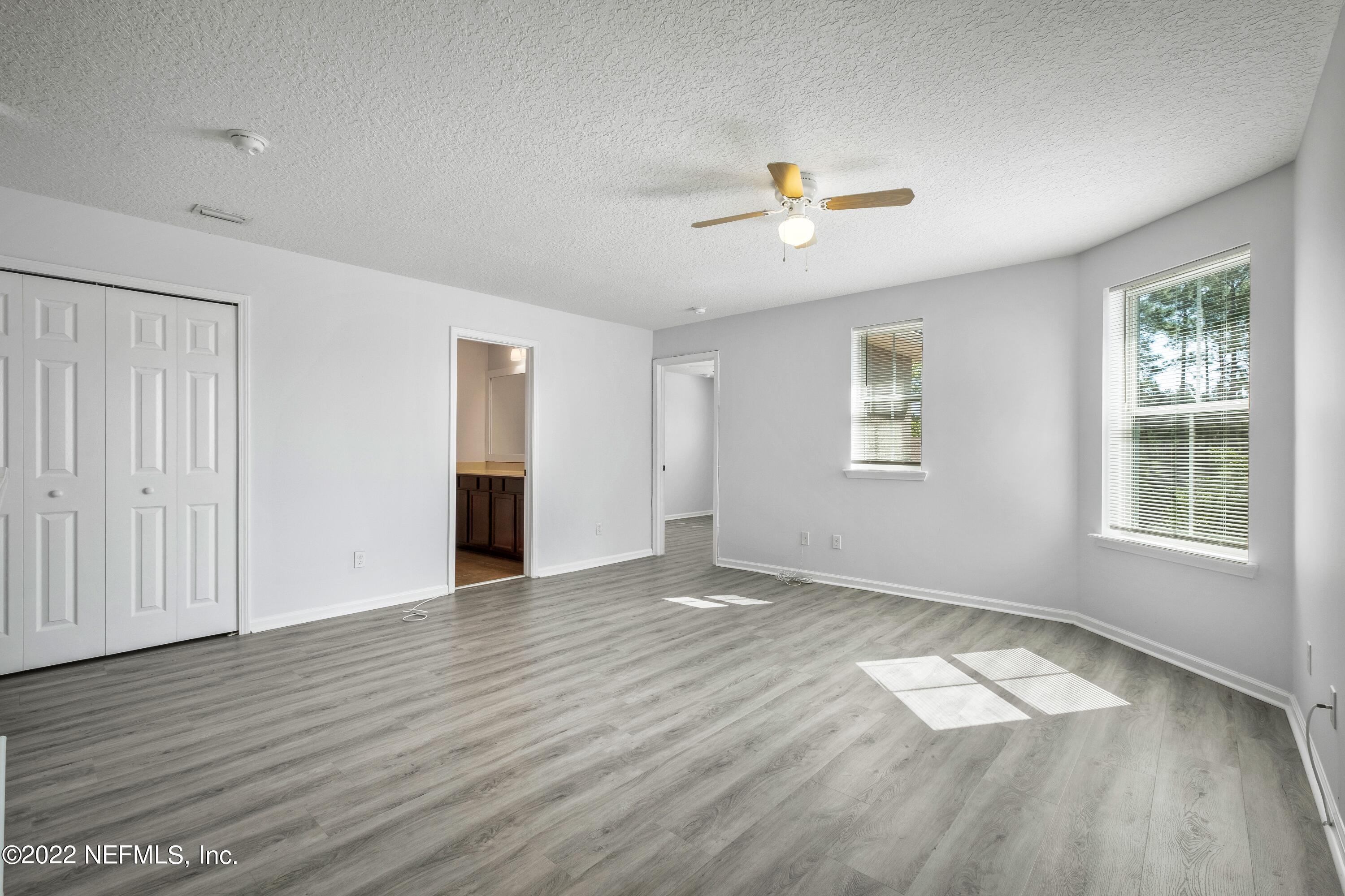 157 Heron Landing Road St. Johns, FL 32259 - Photo 22 of 40 an empty room with wooden floor and windows