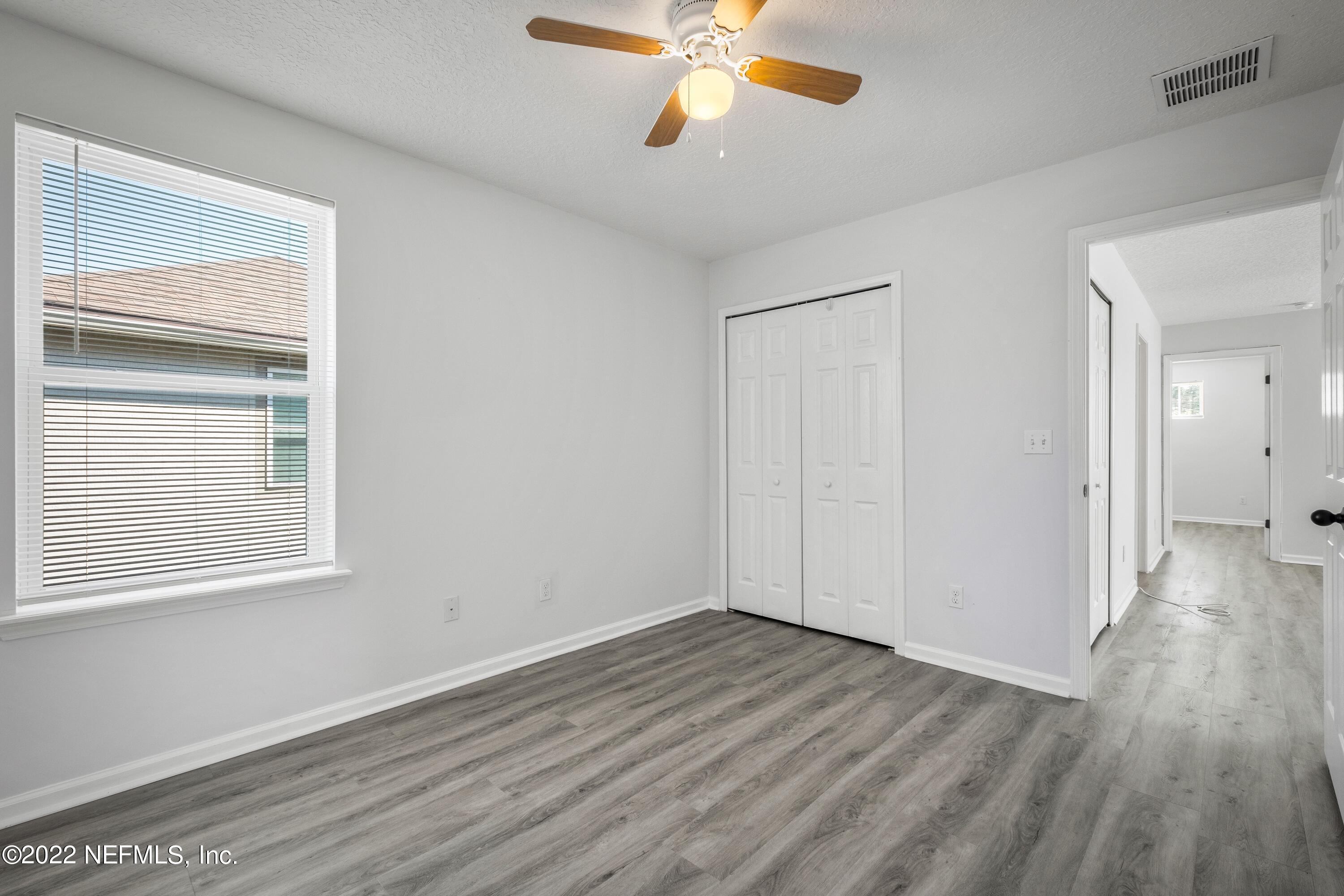 157 Heron Landing Road St. Johns, FL 32259 - Photo 28 of 40 a view of an empty room with wooden floor and a window