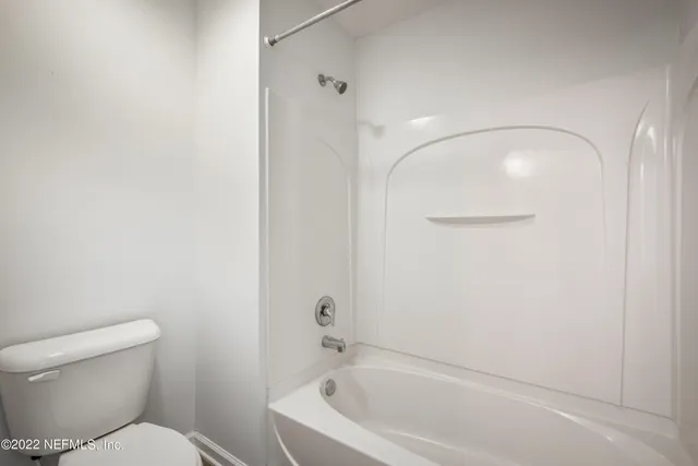 an empty room with a window and a ceiling fan