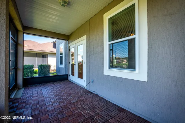 a view of a house with a yard potted plants and a table