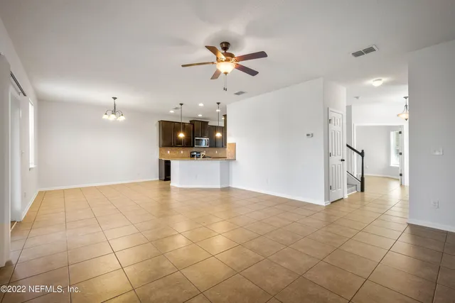 a view of a big room with a ceiling fan and a window