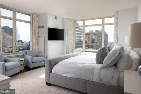 a bedroom with a bed and large window