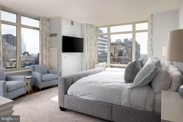 a bedroom with a bed and large window