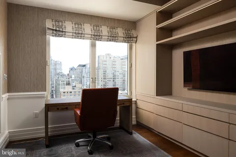 a view of a workspace with furniture and a window