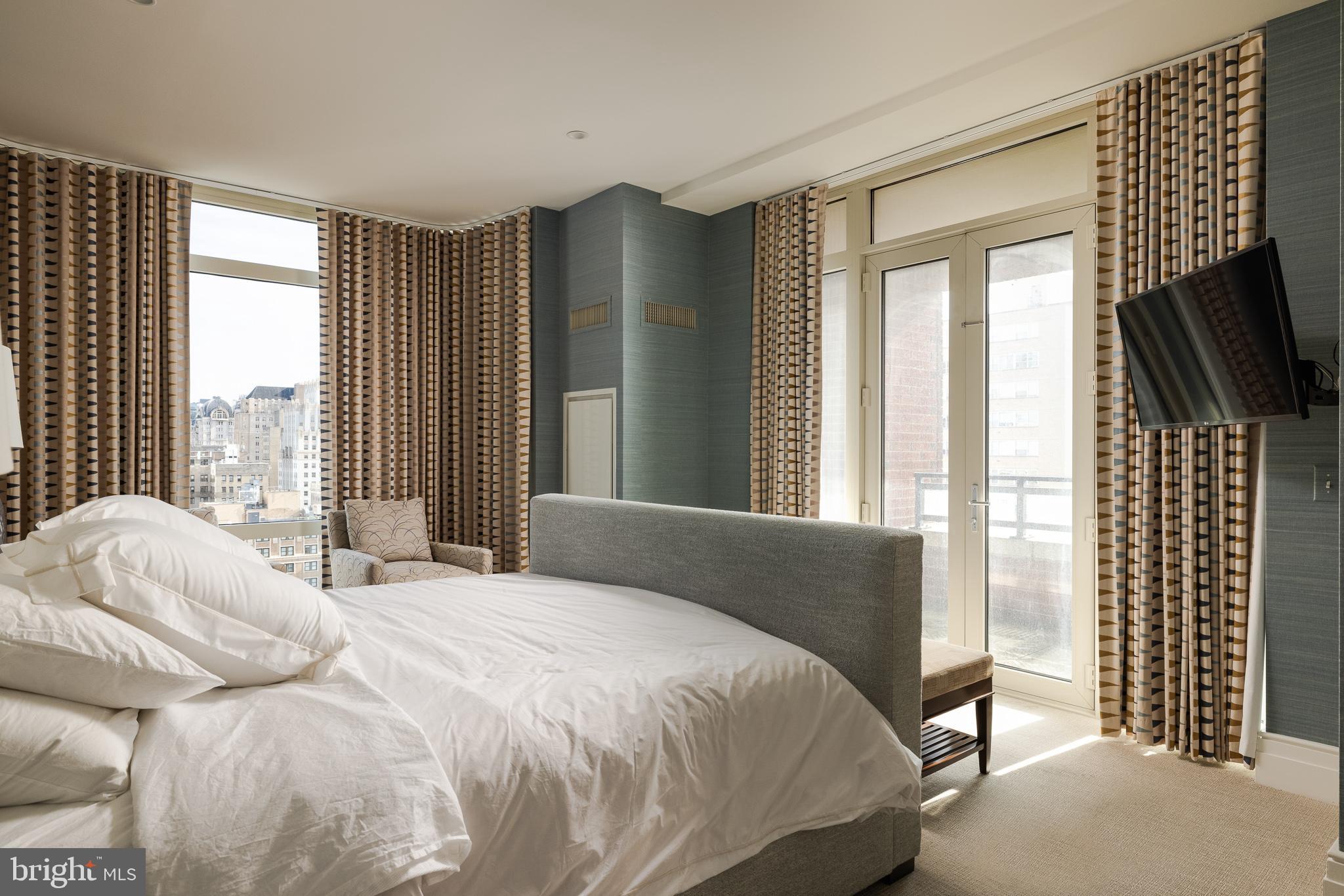 130 South 18th Street, Unit 1804 Philadelphia, PA 19103 - Photo 19 of 36 a bedroom with a bed flat screen tv and windows