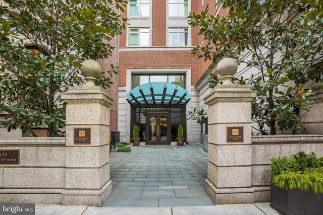 a view of a white house with large windows and a tree