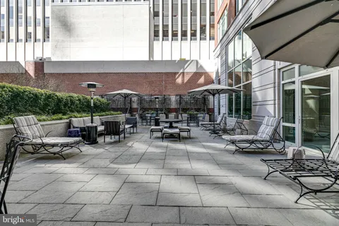 a view of a patio with table and chairs and floor to ceiling window