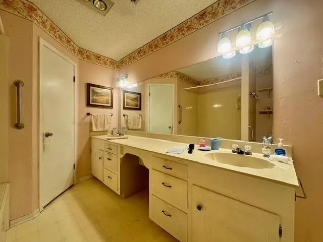 a spacious bathroom with a double vanity sink a mirror and a shower