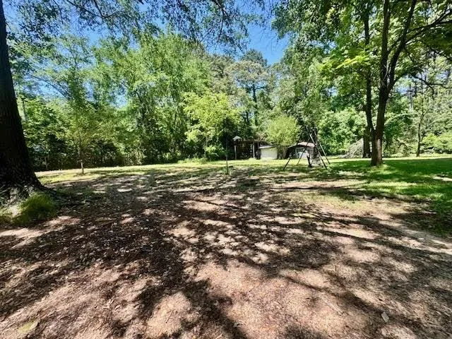 a big yard with lots of green space and trees