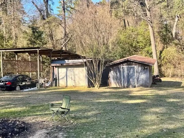a view of a house with backyard and trees