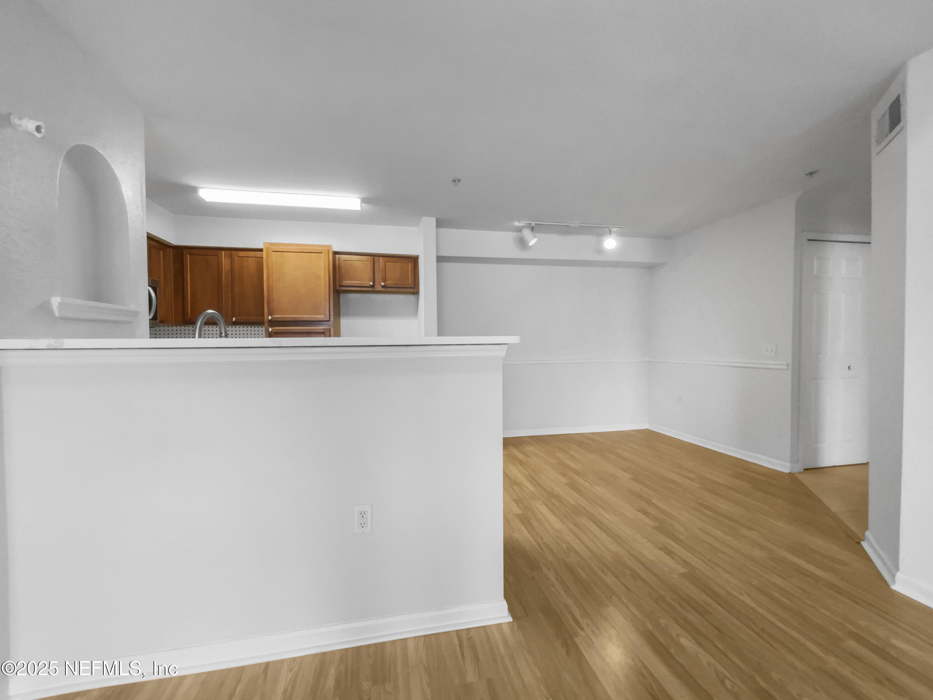 8550 Touchton Road, Unit 635 Jacksonville, FL 32216 - Photo 11 of 25 a view of kitchen and empty room with wooden floor