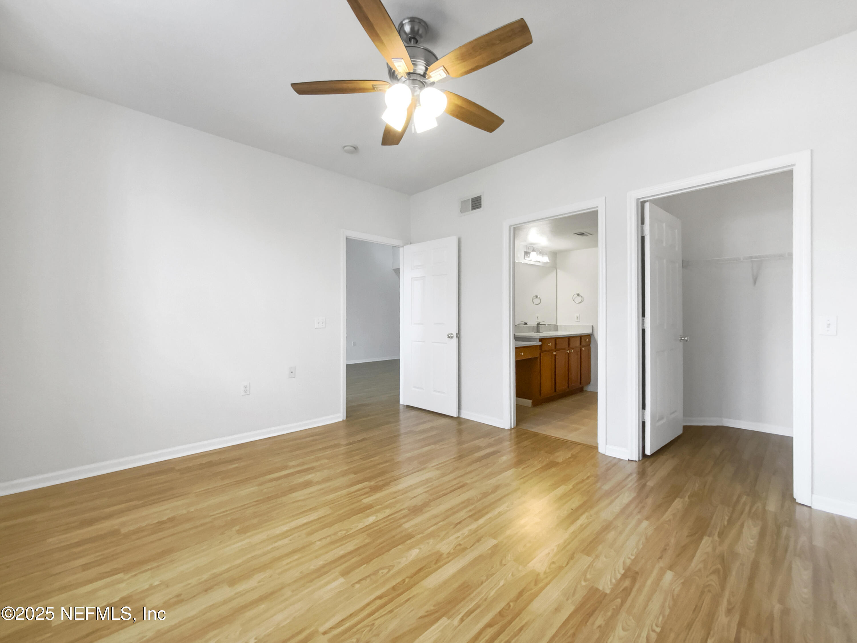 8550 Touchton Road, Unit 635 Jacksonville, FL 32216 - Photo 14 of 25 an empty room with wooden floor and a ceiling fan