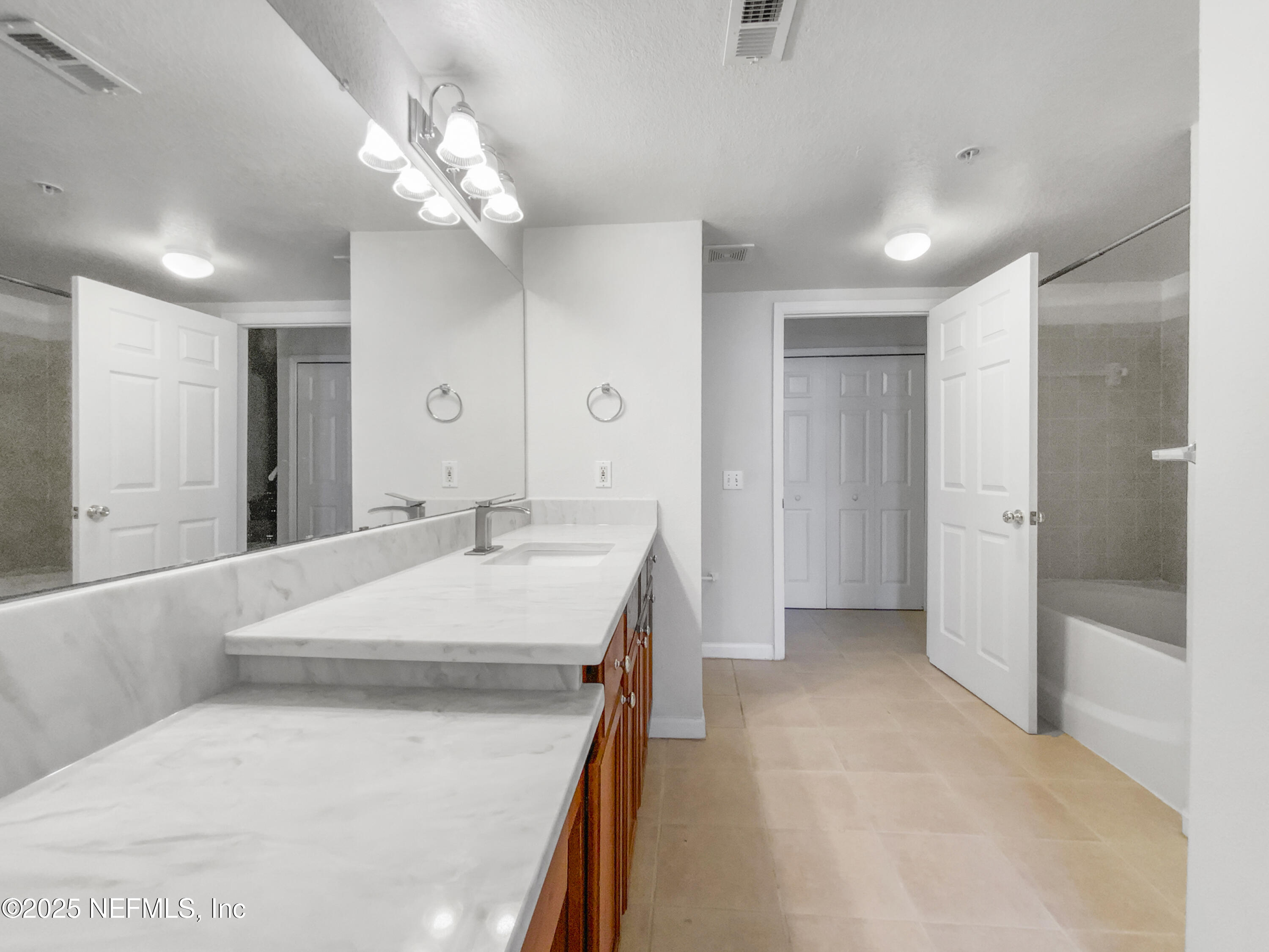 8550 Touchton Road, Unit 635 Jacksonville, FL 32216 - Photo 22 of 25 a bathroom with a sink a large mirror and shower