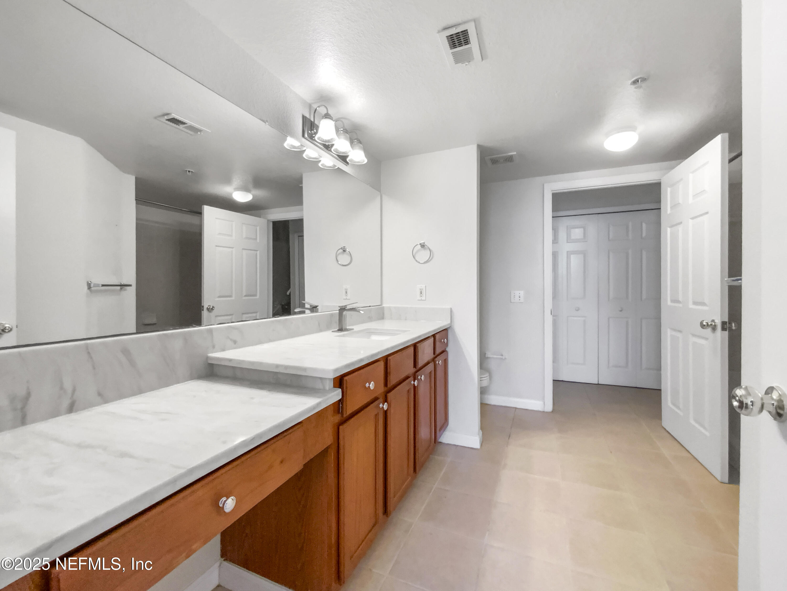 8550 Touchton Road, Unit 635 Jacksonville, FL 32216 - Photo 23 of 25 a spacious bathroom with a granite countertop sink a mirror and a shower
