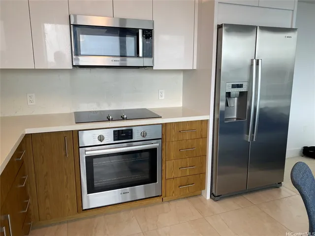 a kitchen with stainless steel appliances granite countertop a stove a microwave and a refrigerator