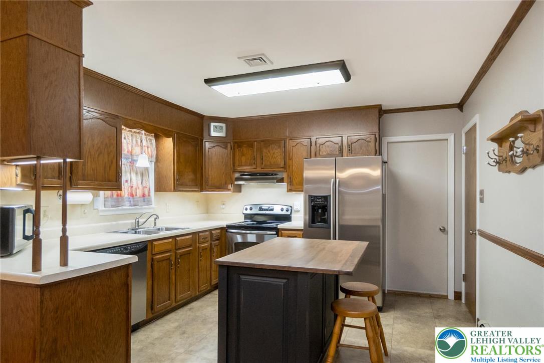1053 Hilltop Road Leesport, PA 19533 - Photo 9 of 46 a kitchen with stainless steel appliances a sink a stove a refrigerator cabinets and a dining table
