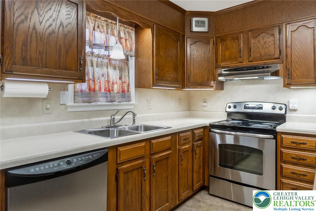 1053 Hilltop Road Leesport, PA 19533 - Photo 10 of 46 a kitchen with granite countertop a sink stainless steel appliances wooden cabinets and a counter top space