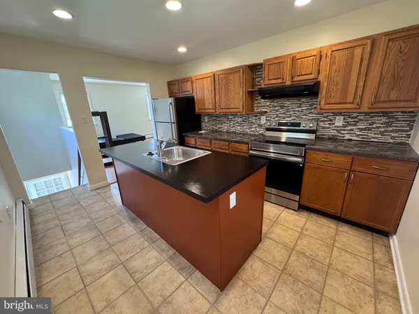 a kitchen with stainless steel appliances granite countertop a stove a sink dishwasher a refrigerator and a microwave