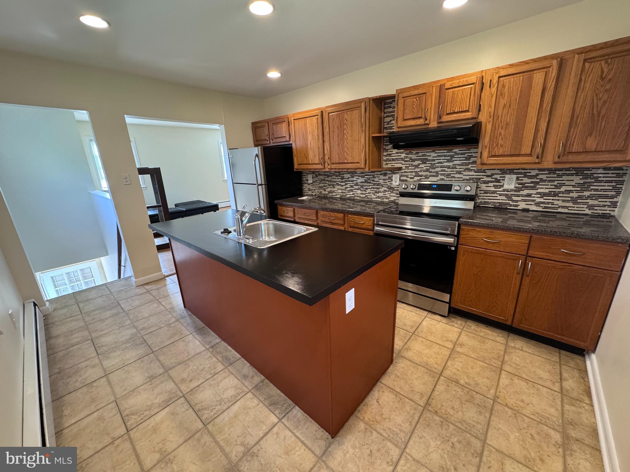 214 Bickley Road Glenside, PA 19038 - Photo 4 of 12 a kitchen with stainless steel appliances granite countertop a stove a sink dishwasher a refrigerator and a microwave