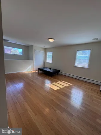 a view of empty room with wooden floor