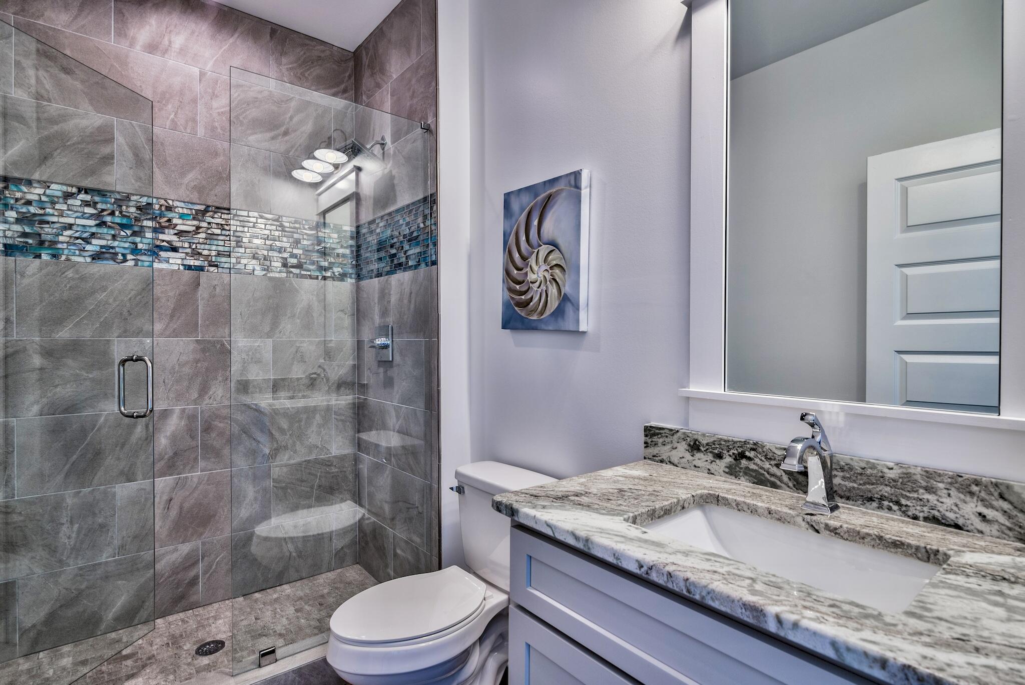 4488 Ocean View Drive Destin, FL 32541 - Photo 21 of 23 a bathroom with a granite countertop sink a toilet a mirror and shower