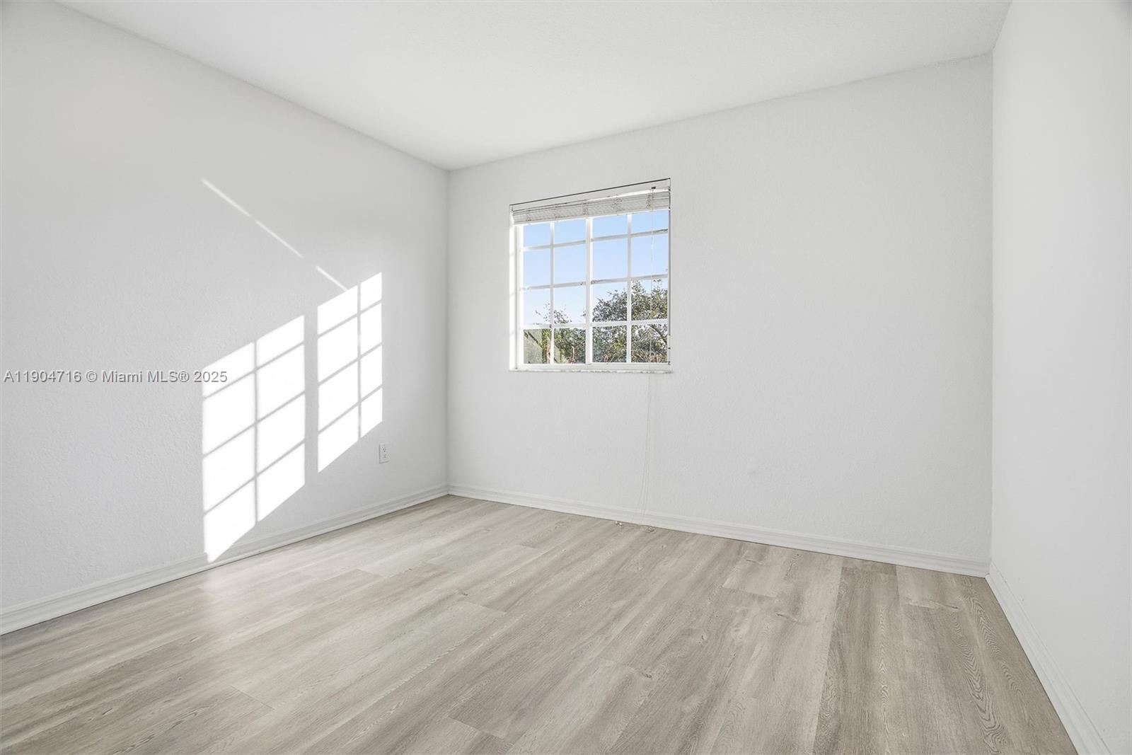 4628 Southwest 125th Lane Miramar, FL 33027 - Photo 30 of 44 an empty room with wooden floor and windows