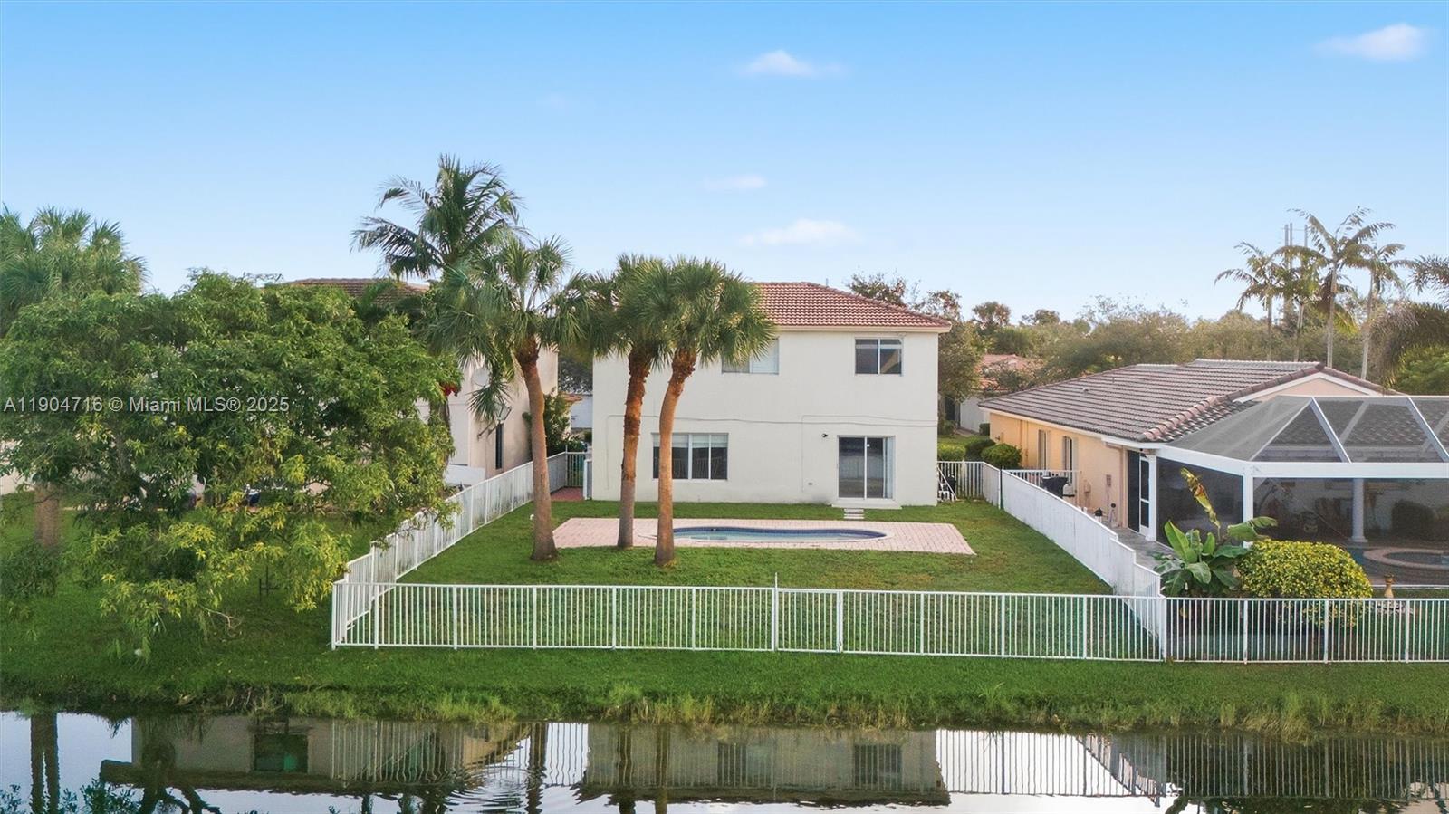4628 Southwest 125th Lane Miramar, FL 33027 - Photo 3 of 44 a front view of a house with a garden and trees